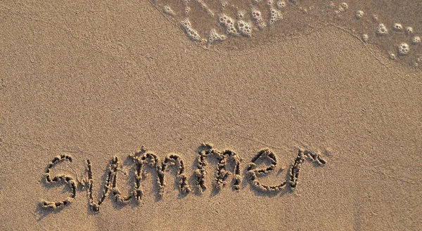 夏天这个词写在沙子上 — 图库照片