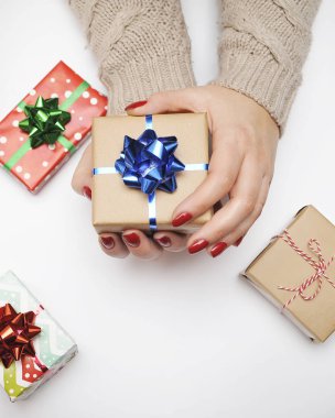 Arkaplanda hediye kutusu olan bir kadın el..