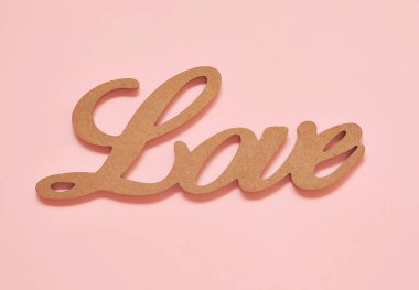 Ahşap kelime Pembe arka planda aşk.