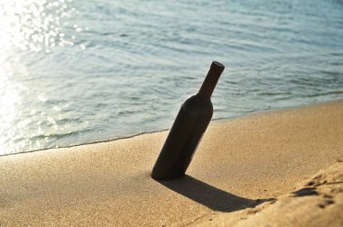 Kumda şarap şişesi. Romantik konsept.