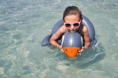 Şirin küçük kız sahilde eğleniyor. Yaz mevsimi kavramı.