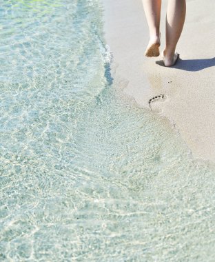 Sahilde kadın ayakları. Yaz konsepti.