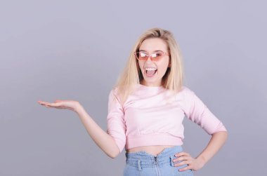 Gülümseyen beyaz kadın gri arka planda poz veriyor..