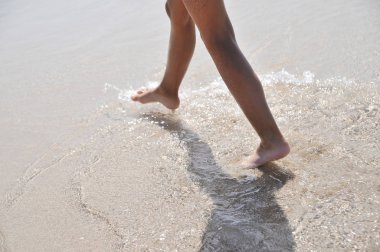 Child legs on sand texture.