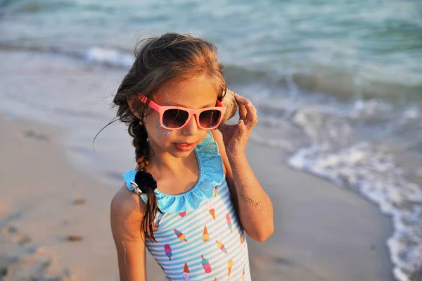 Μικρό Χαριτωμένο Κορίτσι Κοχύλια Στην Παραλία Φόντο — Φωτογραφία Αρχείου