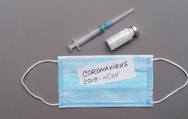 コロナウイルスの概念 コロナウイルスの症状の碑文を持つ保護マスクと論文 — ストック写真