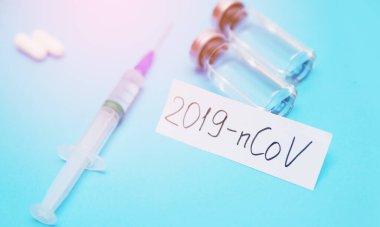 Coronavirus. 2019-Ncov konsepti. Şırınga, aşı, hap ve üzerinde Coronavirüs yazan kağıt..