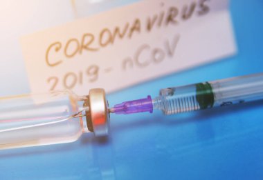 Coronavirus. 2019-Ncov konsepti. Şırınga, aşı, hap ve üzerinde Coronavirüs yazan kağıt..