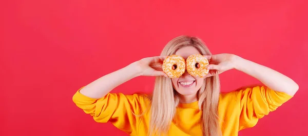 Usmívající Běloška Žena Žlutém Svetru Žlutými Koblihami Pózující Červeném Pozadí — Stock fotografie