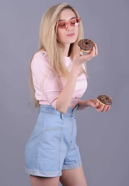 Улыбающаяся Белая Женщина Розовом Свитере Шоколадными Пончиками Позирует Сером Фоне — стоковое фото