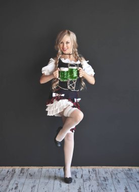 Elinde bir bardak yeşil bira olan kadın. Aziz Patrick Günü.