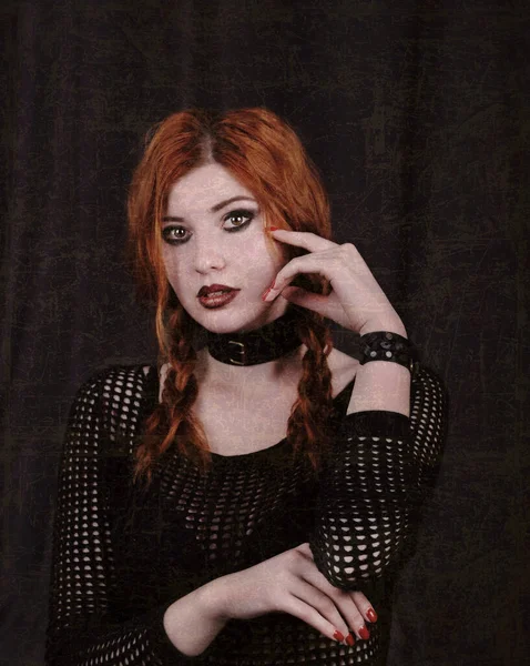 Beautiful gothic woman posing on dark background.
