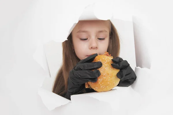 Schattig Klein Meisje Met Zwart Handschoenen Eet Hamburger — Stockfoto
