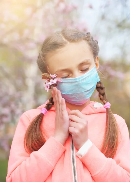 Little girl with medicine mask outdoors.