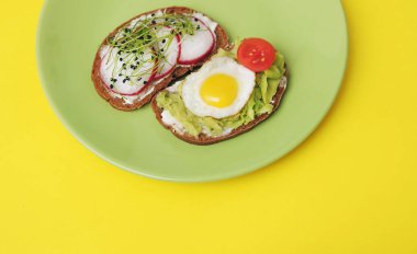 Sağlıklı sebzeli sandviçler ve renkli arka planda mikro yeşiller..