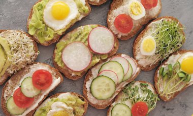 Sebzeli sandviçler, yumurta, avokado ve taştan arka planda mikro yeşiller. Sağlıklı yemek..