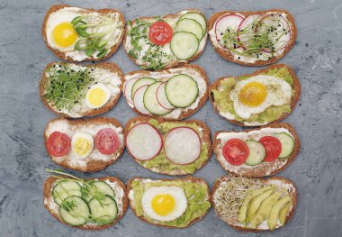 Sebzeli sandviçler, yumurta, avokado ve taştan arka planda mikro yeşiller. Sağlıklı yemek..