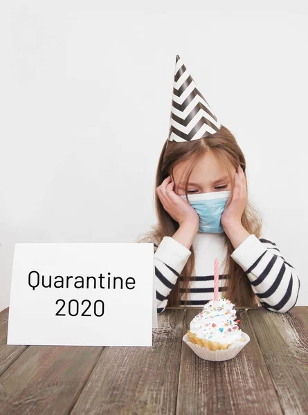 Sad little girl celebrates birthday at home alone. Quarantine birthday.