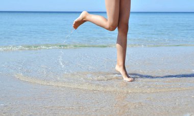 Sahilde çocuk bacakları.