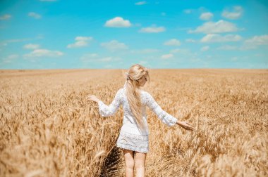 Çayırda buğdaylı poz veren kadın.