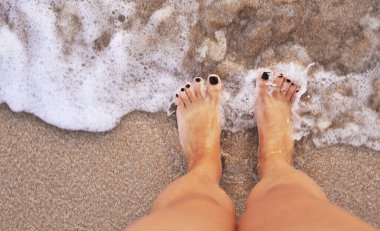 Kum dokusunda kadın bacakları.