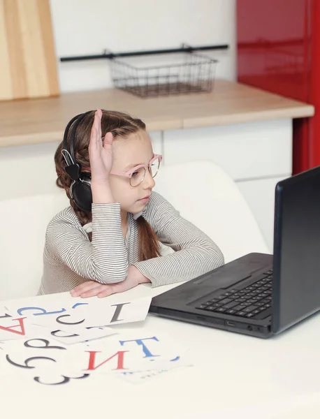 Girl with laptop and headphones at home school education. Onling learning.