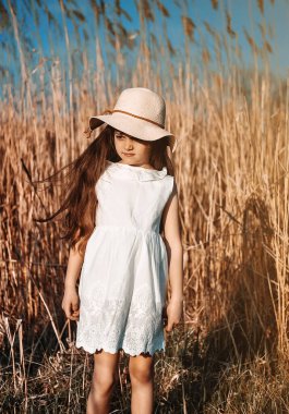 Şapkalı küçük tatlı kız dışarıda eğleniyor..