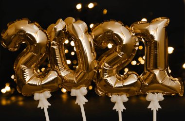 Şenlik arka planında 2021 sembolleri parlayan balonlar.