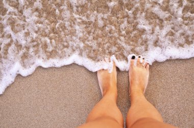 Kum dokusunda kadın bacakları.