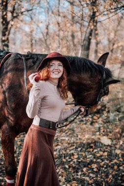 Güzel kızıl saçlı bir kadının açık havada çekilmiş portresi..