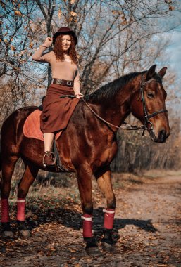 Güzel kızıl saçlı bir kadının açık havada çekilmiş portresi..