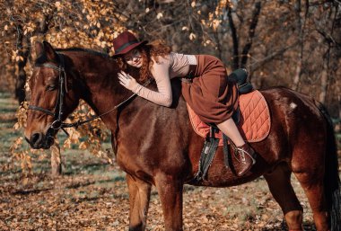 Güzel kızıl saçlı bir kadının açık havada çekilmiş portresi..