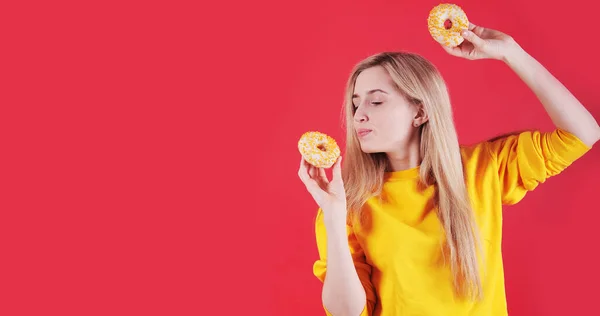 Kaukasische Vrouw Met Gele Donuts Poseren Rode Achtergrond Studio — Stockfoto