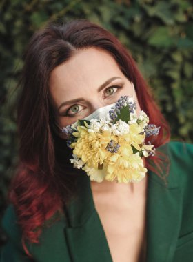 Koruyucu maskeli, çiçekli güzel bir kadının portresi..