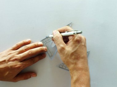 Elleri üstte okul malzemeleriyle çalışan beyaz ofis masası