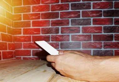 Beyaz ekranlı akıllı telefon kullanan genç bir adam.