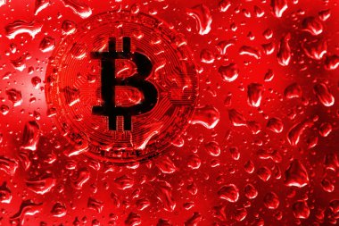 sikke bitcoin kırmızı damla ile cam arkasında.