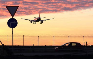 Yolcu uçağı iniş havaalanında güneş ışınlarının içinde geliyor