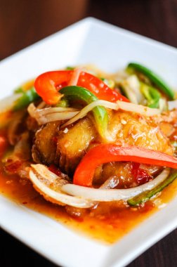 Kırmızı sıcak Snapper, biber, soğan, taze sarımsak ve biber ile kırmızı balığı fileto tepesinde kızarmış tatlı ve ekşi soslu karışık