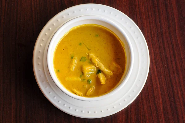 Sarı köri, hafif bir köri sos ve patates ve yeşil bezelye ile Hindistan cevizi sütü.