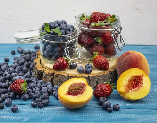 Fresh fruits. Healthy food. Mixed fruit, strawberries and blueberries, peaches. Studio photography of various fruits on an old wooden table. Organic healthy assorted fruits. Assortment of fresh fruit. Fruit food background. place for text