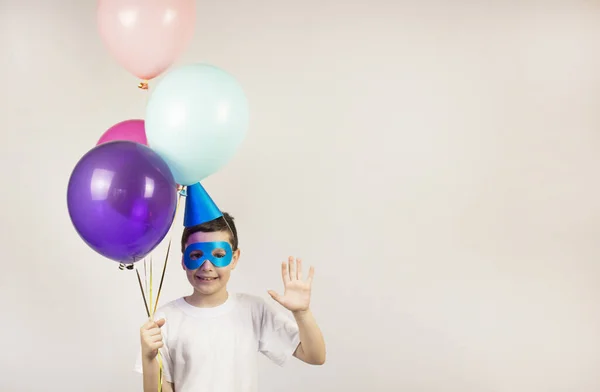 Festive balloons. Happy birthday concept. Birthday with festive colorful balloons. Joyful children. Celebrate your birthday poster. Banner. The boy in the hat and glasses. Place for text