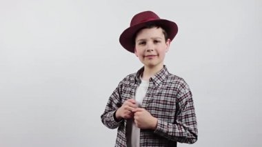 Mutlu çocuk beyaz bir arka planda izole edilmiş. Ekose gömlekli ve şapkalı bir çocuk. kopyalama alanı