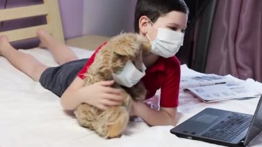Çocuk ayıya sarılıyor. Maskeli çocuk. Maskeli ayı. Çevrimiçi sohbet. Corona virüsü. Karantina