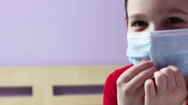 Dizüstü bilgisayardaki maskeli çocuk. Gülümsüyor. Çevrimiçi dersler. Karantinaya alın. Evde eğitim. Kişisel tecrit