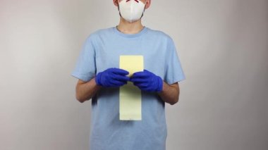 Bağış. Eldivenli ve maskeli bir adam, içinde bağış olan bir kese kağıdı tutuyor. Tuvalet kağıdı. Bağış Konsepti. Yiyecek bağışı. Kopyalama alanı