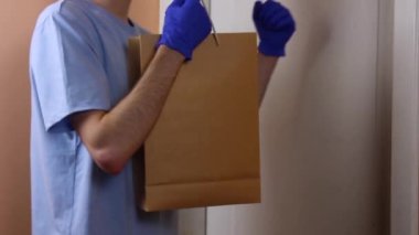 Maskeli ve eldivenli adam yaşlı ve muhtaçlara bağışta bulunuyor. Sosyal yardım