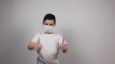 Karantinaya alın. Coronavirus. Maskeli ve beyaz tişörtlü bir çocuk maske istiyor. Enfeksiyon ve virüslere karşı koruyucu maske. Koru kendini. Metin için yer