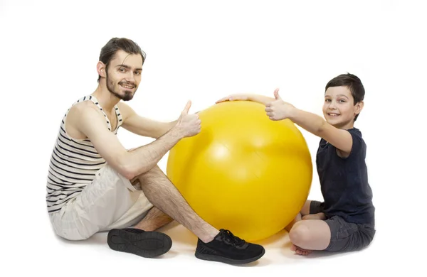 Fitness antrenmanı ve fitball antrenmanı. Sarı bir fitbol topu olan iki adam. İzole et. Pankart. Kopyalama alanı