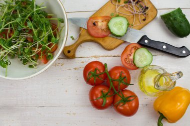 Salatalık ve domatesli taze salata. Sağlıklı beslenme kavramı. Beyaz ahşap arka planda karışık sebze salatası. Yukarıdan bak. kopyalama alanı